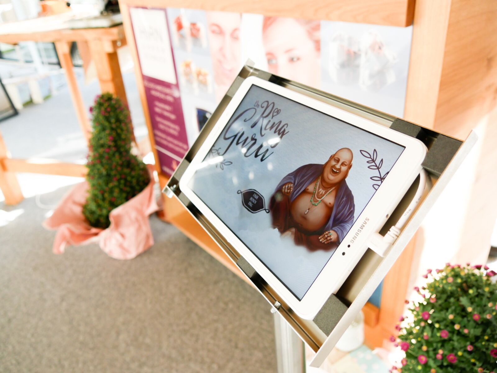 Tablet auf einem Messestand zeigt die Startseite des Ring Guru.