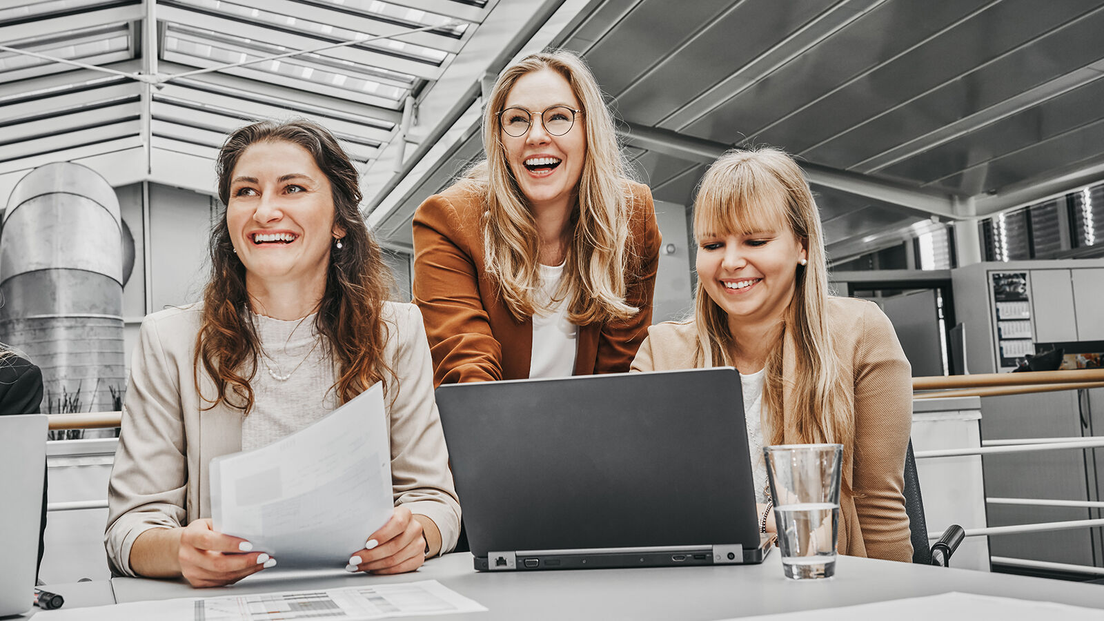 Employer Branding für GARTNER: drei Kolleginnen lachen gemeinsam über einem Laptop im Büro.