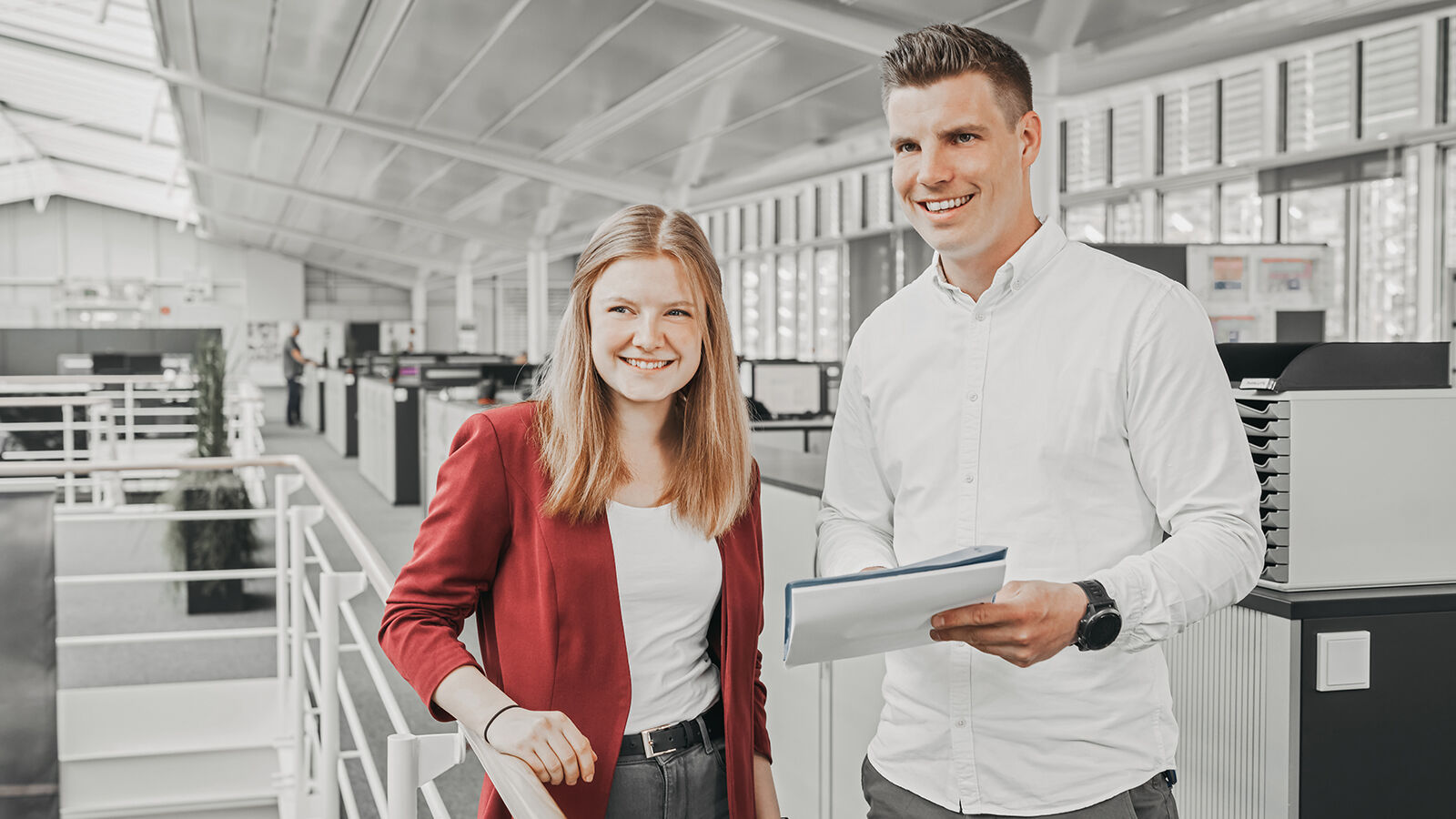 Employer Branding für GARTNER: zwei Beschäftigte im Großraumbüro, die Umgebung in Schwarzweiß, die Personen in Farbe.