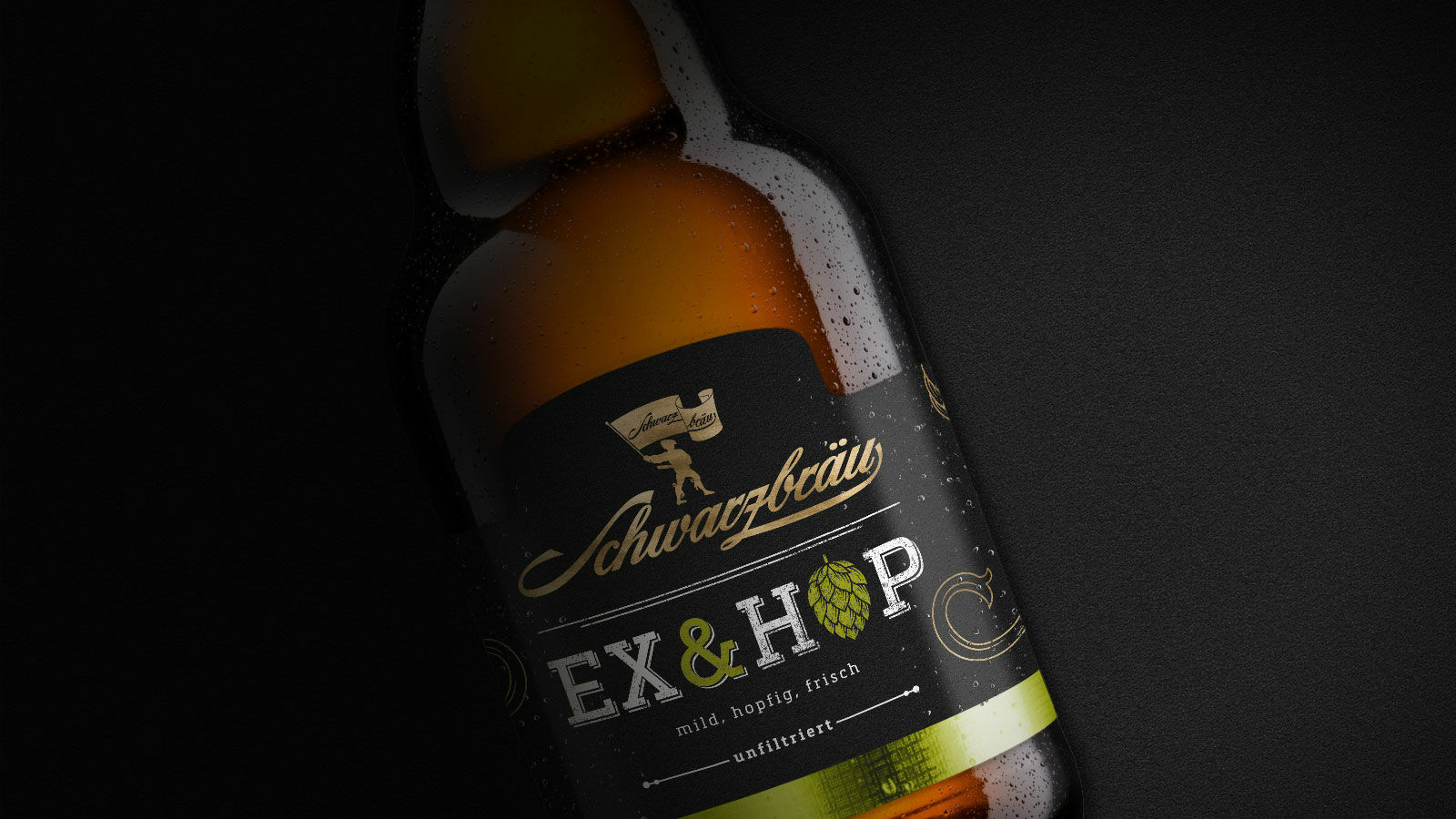 Beschlagene Flasche Ex & Hop von Schwarzbräu mit schwarzgoldenem Etikett und grüner Hopfendolde.