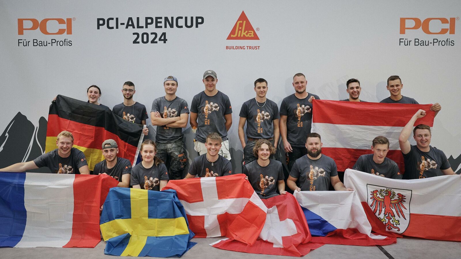 PCI-Alpencup 2024: Gruppenbild aller Teilnehmer mit den Flaggen ihrer Länder.