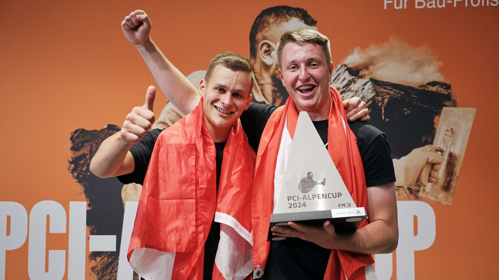 PCI-Alpencup 2024: zwei Teilnehmer feiern mit dem Siegerpokal.