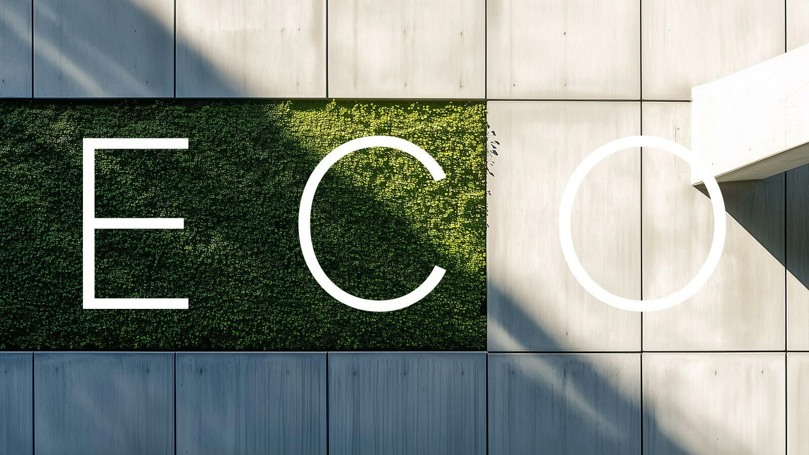 Fassade mit den Buchstaben ECO, teils auf einer begrünten Wand, teils auf Sichtbeton.
