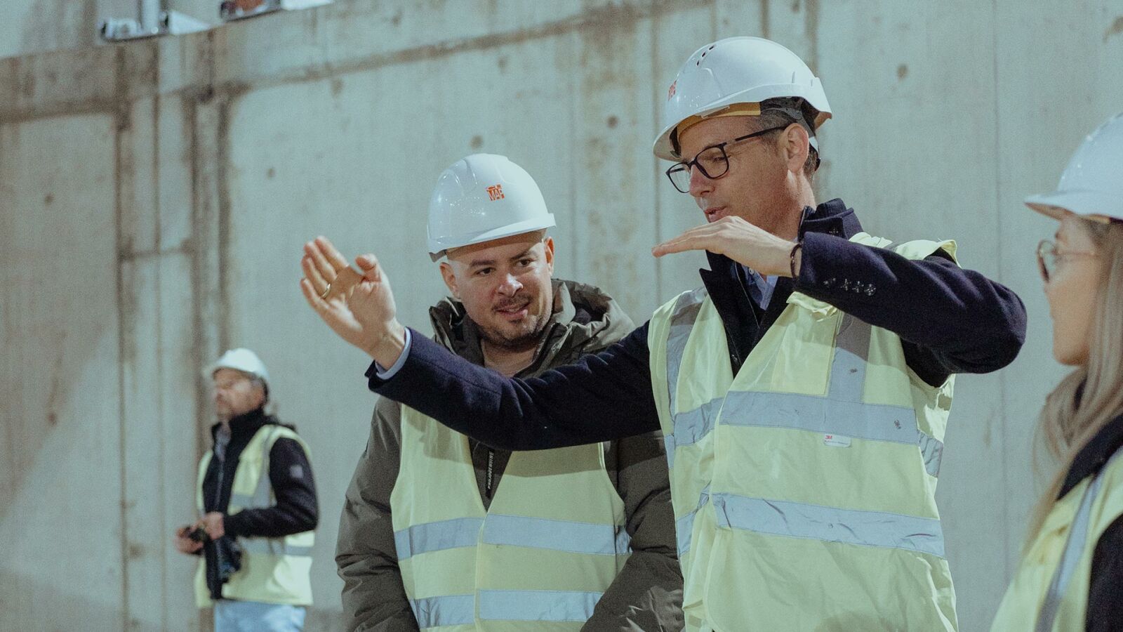 Zwei Männer von CL MAP in Warnwesten besprechen im Rohbau die Deckenhöhe.