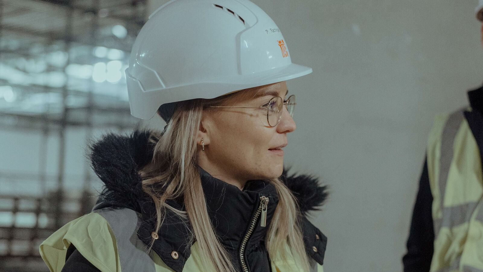 Eine Mitarbeiterin von CL MAP mit Helm im Gespräch auf der Baustelle.
