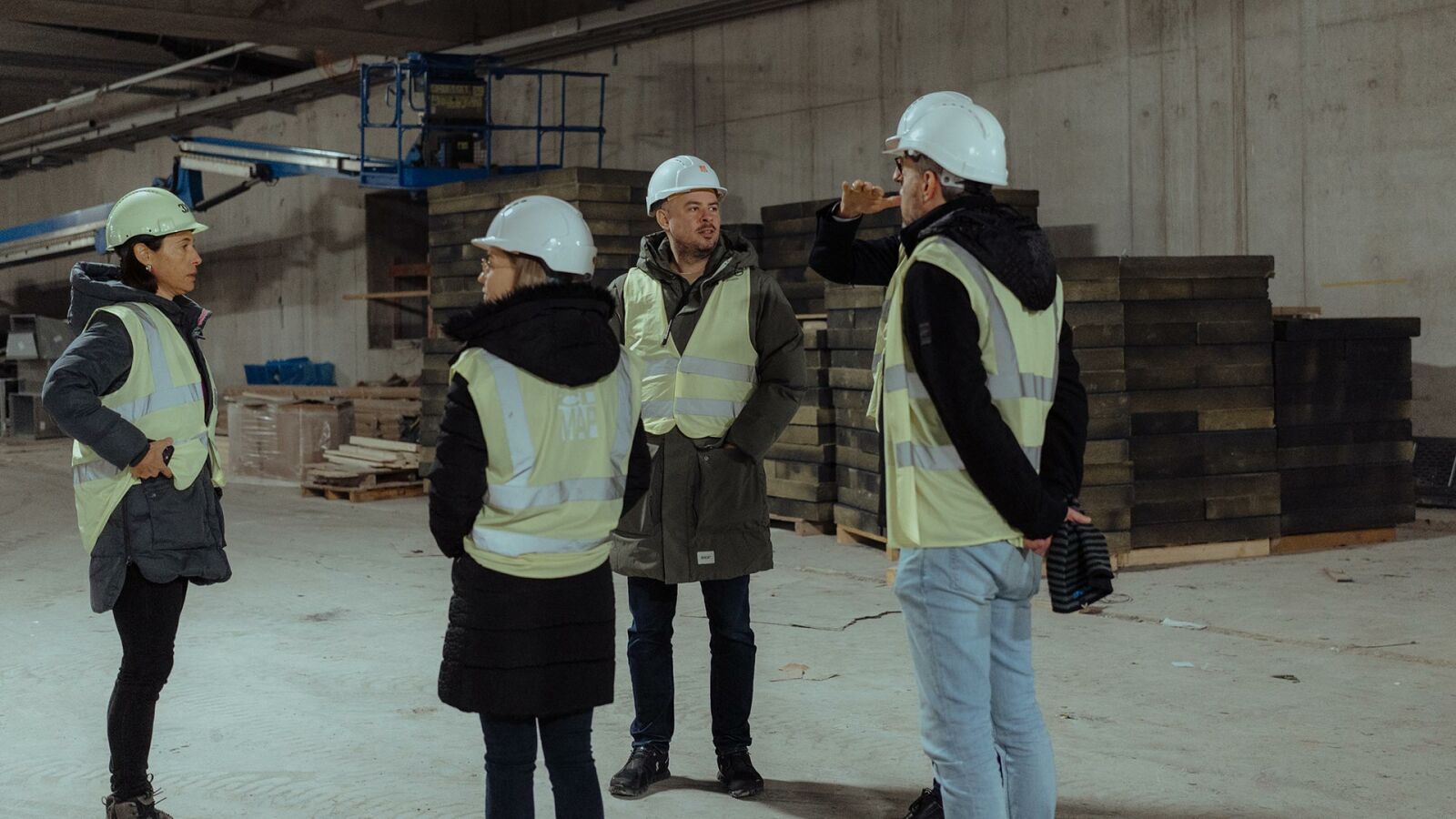Vier Personen von CL MAP in Warnwesten bei der Baustellenbegehung in einer Tiefgarage.